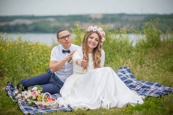 Nevěsta a ženich na trávě v parku — Stock fotografie