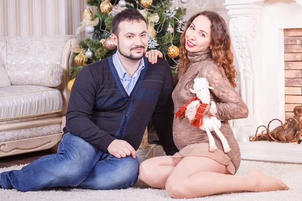 Těhotná pár sedí na podlaze — Stock fotografie