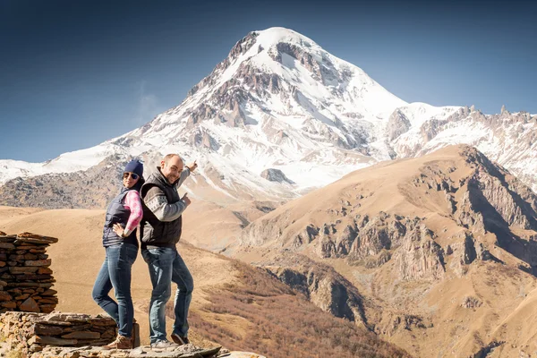 Joven pareja en un fondo de montañas — Foto de Stock