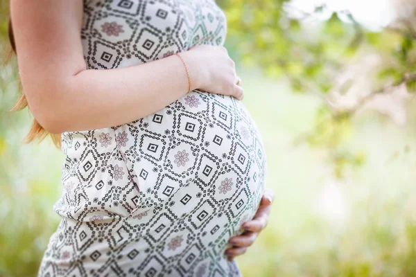 Pregnant holding her stomach — Stock Photo, Image