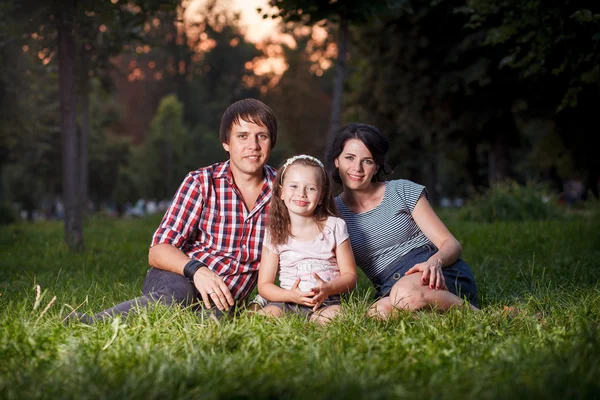 Família sentada na grama — Fotografia de Stock