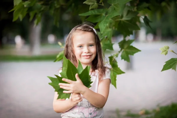 Meisje en groene bladeren — Stockfoto