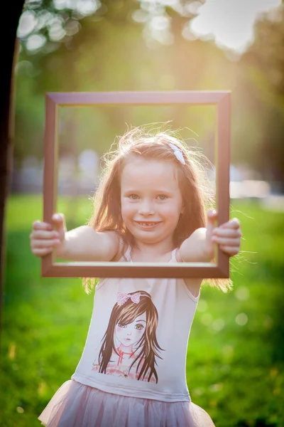 Liten flicka och ram — Stockfoto