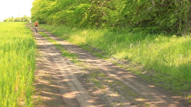 A cyclist on a dirt road — Stock Video