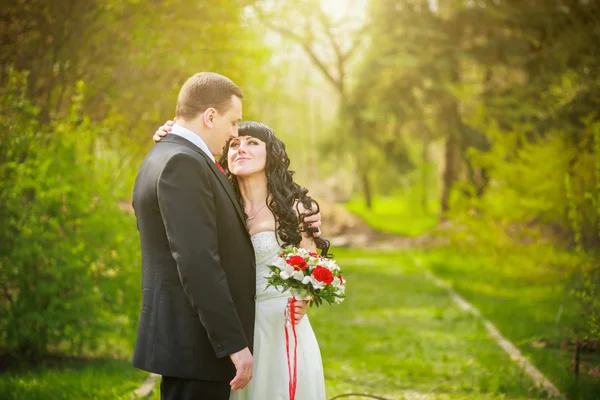 Ο γαμπρός και η νύφη σε ένα καταπράσινο πάρκο — Φωτογραφία Αρχείου
