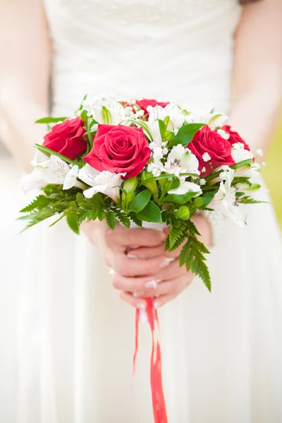 A bridal bouquet of roses in hands of the bride — Stock Photo, Image