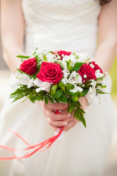 A bridal bouquet of roses in hands of the bride — Stock Photo, Image