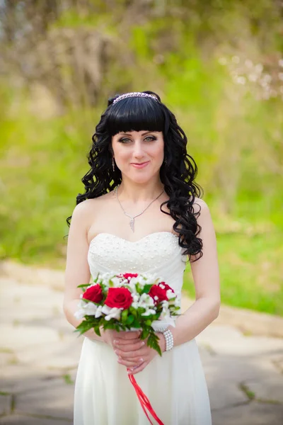 A bridal bouquet of roses in hands of the bride — Stock Photo, Image