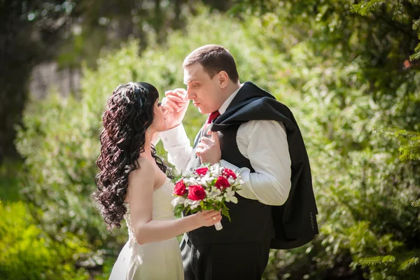 O noivo e a noiva em um parque verde — Fotografia de Stock