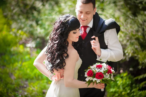 De bruidegom en de bruid in een groen park — Stockfoto