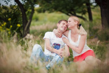 Parkta çimlerde oturan Çift