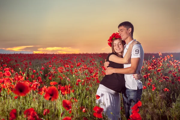 Pregnant couple, poppies — Stock Photo, Image