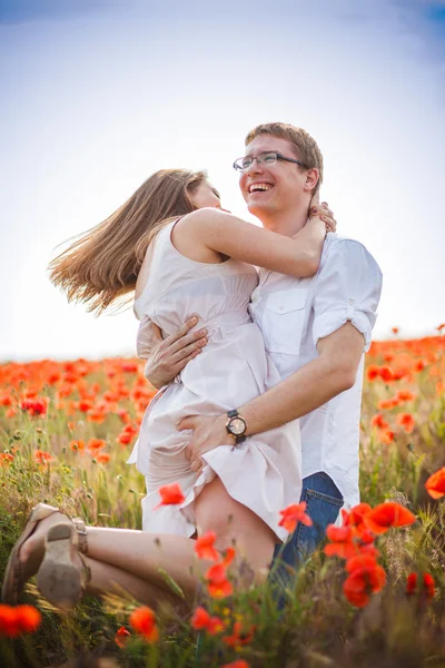 Young couple in the poppy field — Stock Photo, Image