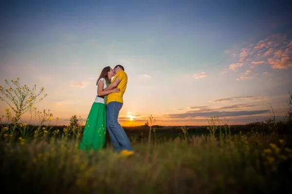 Young couple sunset, green field — Stock Photo, Image