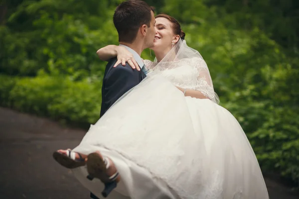 Ženich nese ruce nevěsty — Stock fotografie