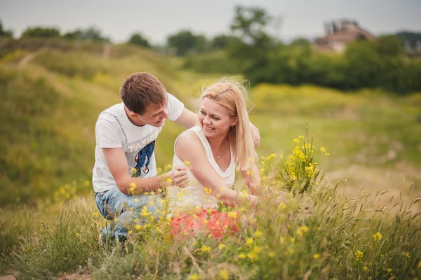 Beautiful young couple in a field — Stock Photo, Image