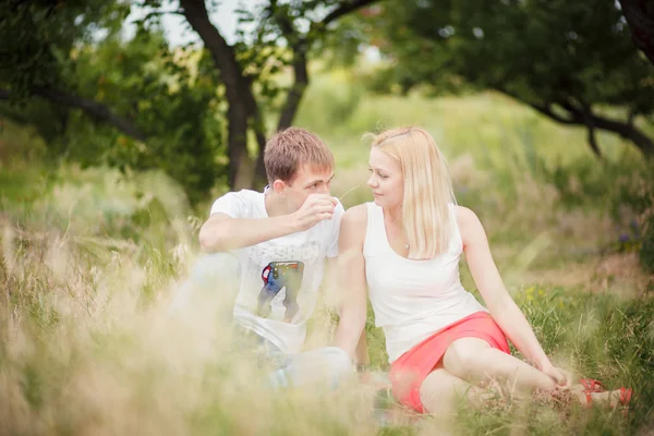 Пара, сидящая на траве в парке — стоковое фото