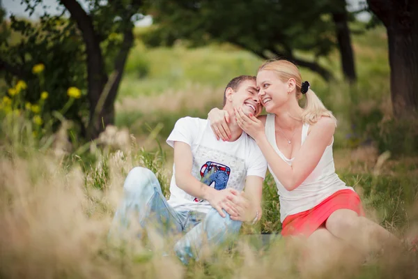 Pár ül a fűben, a parkban — Stock Fotó