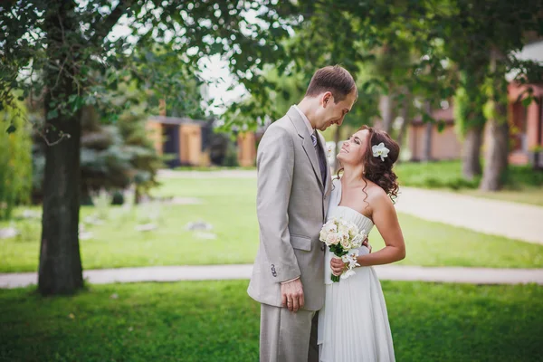 Невеста и жених на фоне зеленого парка — стоковое фото