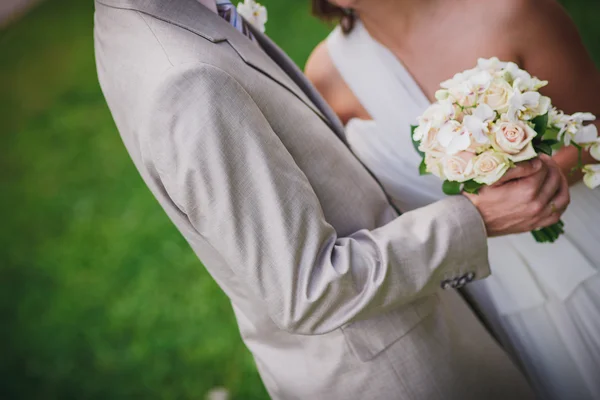 Kytice v rukou novomanželů — Stock fotografie