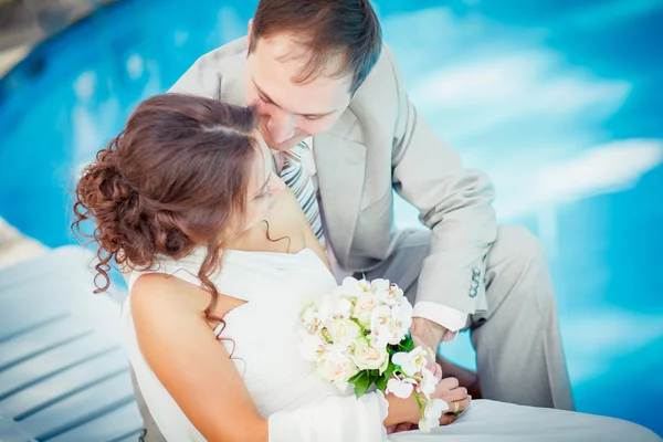 Sposo e sposa vicino alla piscina — Foto Stock