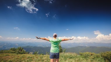bir dağın tepesinde duran kadın