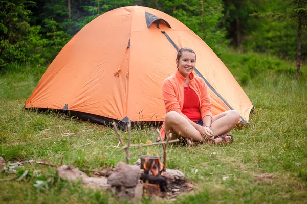 Девушка-туристка сидит возле палатки — стоковое фото