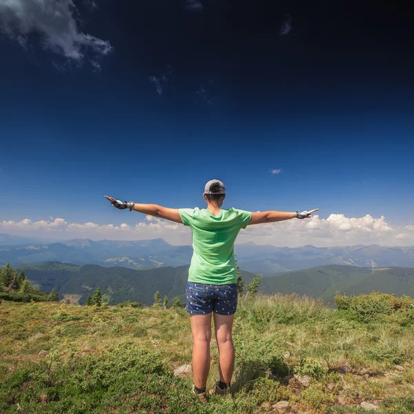 Mujer de pie en la cima de una montaña — Foto de Stock