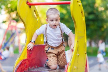 küçük çocuk üstünde belgili tanımlık tepe oynarken