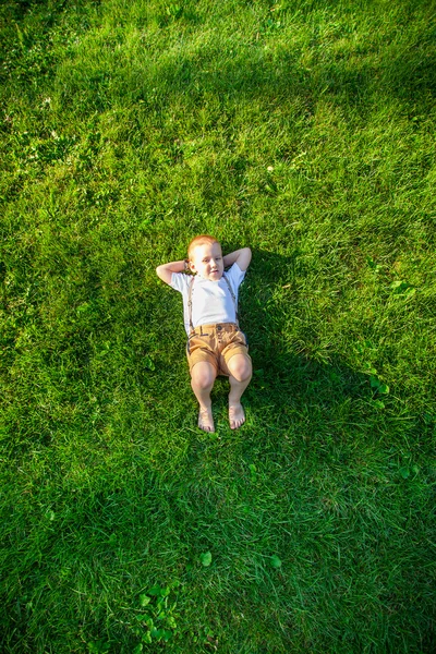 Jongen liggen op het gras — Stockfoto