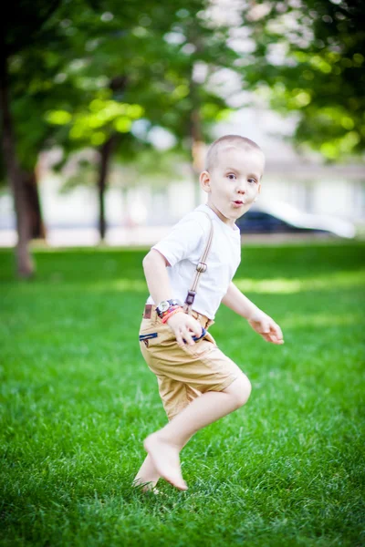 Çimenlerin üzerinde çalışan çocuk — Stok fotoğraf