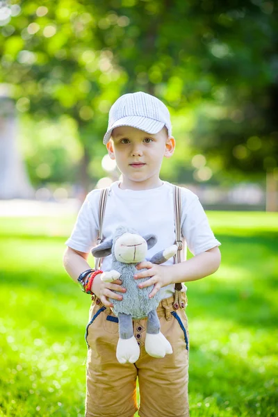 Kleine jongen met een zacht stuk speelgoed in het park — Stockfoto