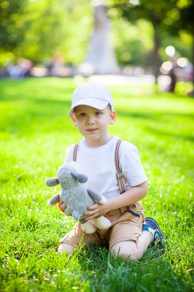 Küçük çocuk çimenlerde oynuyor. — Stok fotoğraf