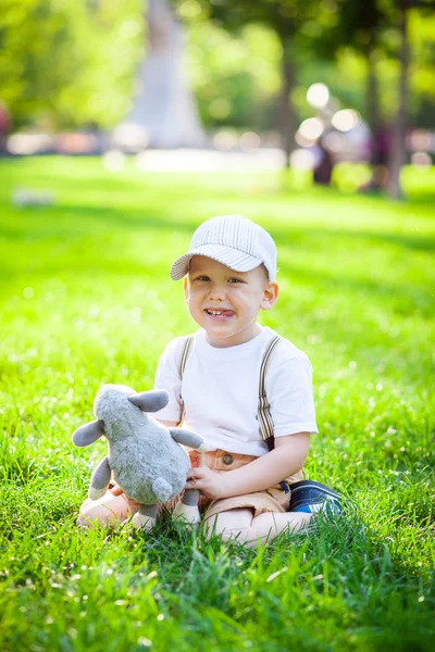 Küçük çocuk çimenlerde oynuyor. — Stok fotoğraf