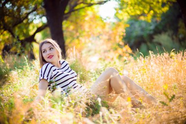 Sarı çim üzerinde oturan kadın