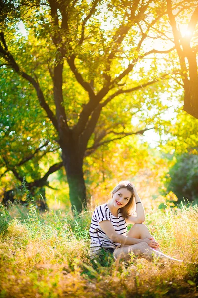 Woman sitting on yellow grass — Stock Photo, Image