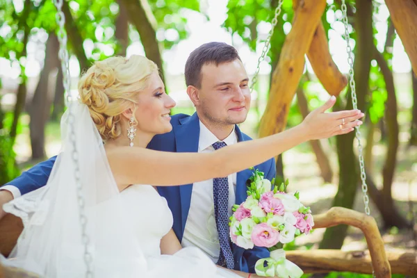 A noiva e o noivo em um balanço — Fotografia de Stock