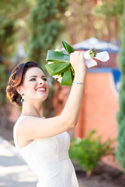 Bridal bouquet in the hands of white roses and green leaves — Stock Photo, Image