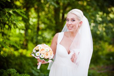 Gelin beyaz elbise gülüyor ve gülümsüyor