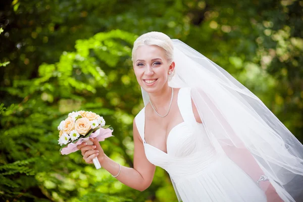 Charmante Braut mit einem Strauß — Stockfoto