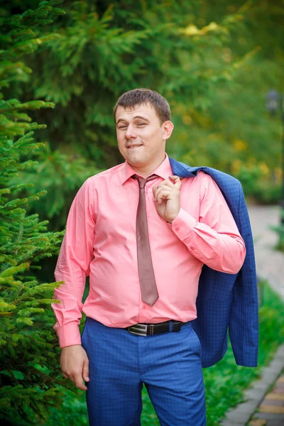 Jonge man met een jas over zijn schouder — Stockfoto