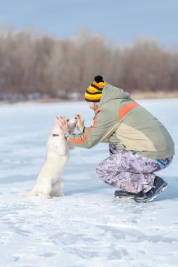 husky bir köpekle oynayan adam