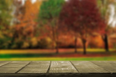 Boş Masa Üst Güz Arkaplanı. Öndeki ahşap tablo ürünlerinizi görüntülemek ya da montajlamak için kullanılabilir. Ürünün gösterimi için modelleyin.