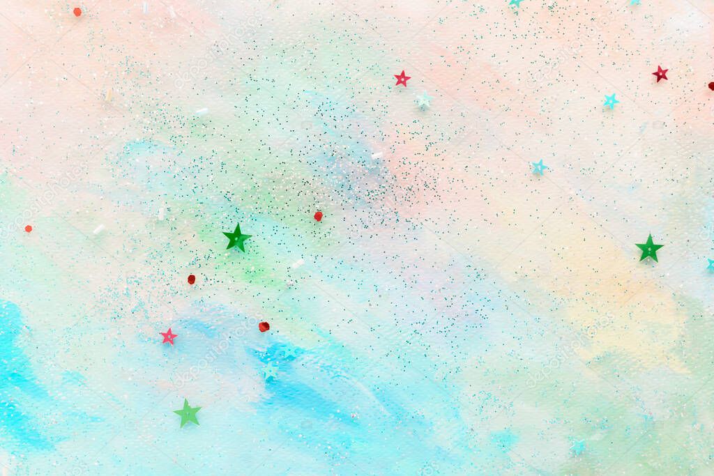 Glittery star confetti on colorful abstract pastel watercolor background