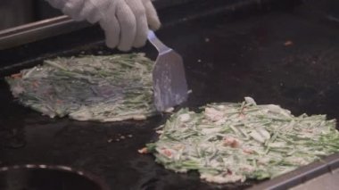 Gukje Uluslararası Pazarı Busan şehrinde Bindae-tteok. Bindaetteok, kızarmış buchimgae, fasulyeli lezzetli gözleme, sebze, et. Güney Kore 'de sokakta yiyecek satan Koreli satıcılar.