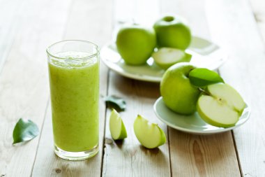 ahşap arka plan üzerinde taze elma suyu çimenlerin üzerinde yumuşak odak