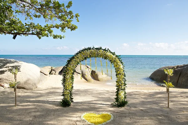 Geel wit verse bloemen strand bruiloft ingesteld met rotsachtige in th — Stockfoto