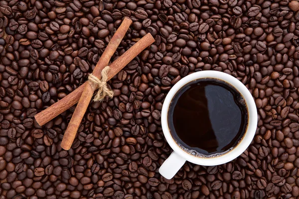 White cup of coffee and cinnamon on top of flat lay of brown roa — Stock Photo, Image