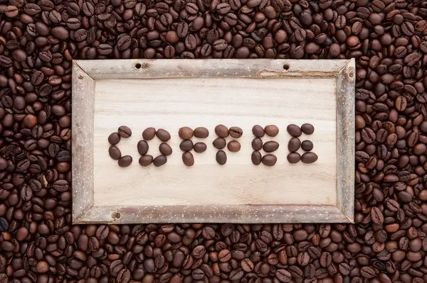 wood frame with coffee word on top of flat lay of brown roasted