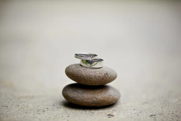 Wedding rings sitting on top of the stone — Stock Photo, Image